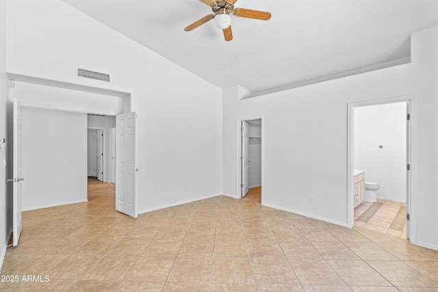 unfurnished bedroom featuring light tile patterned flooring, ensuite bath, high vaulted ceiling, a spacious closet, and visible vents