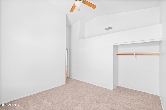 unfurnished bedroom with visible vents, vaulted ceiling, baseboards, a closet, and carpet flooring