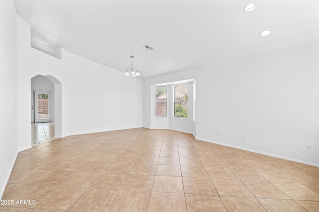spare room featuring visible vents, arched walkways, vaulted ceiling, a chandelier, and light tile patterned flooring
