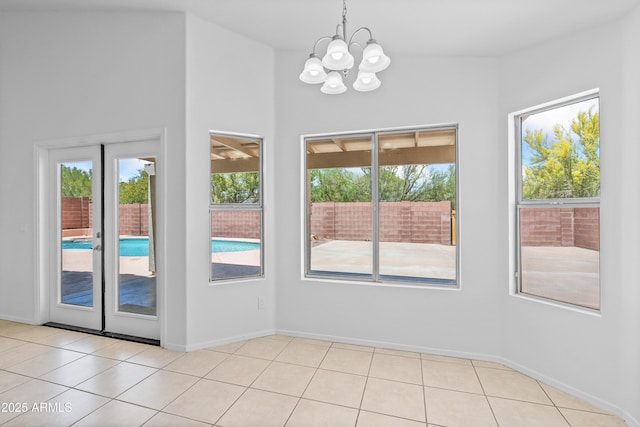 interior space featuring baseboards, a chandelier, and light tile patterned floors