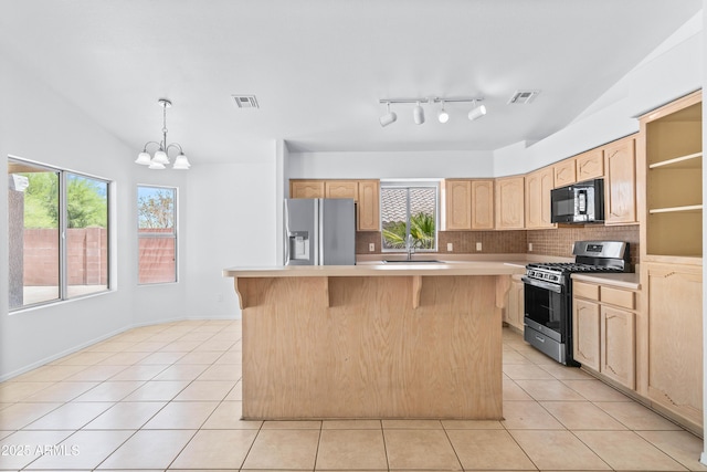 kitchen featuring light brown cabinetry, stainless steel appliances, visible vents, and light countertops