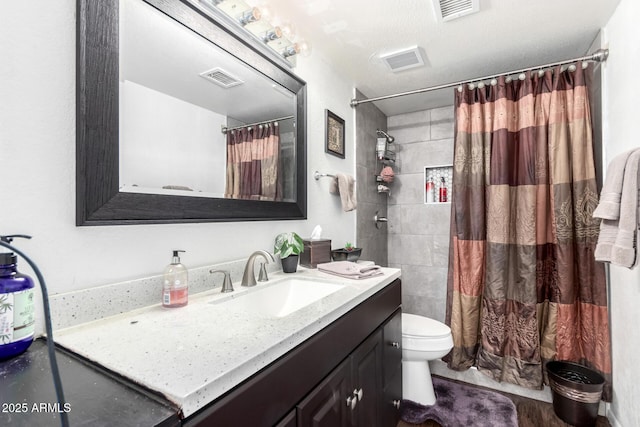 bathroom with curtained shower, vanity, a textured ceiling, and toilet