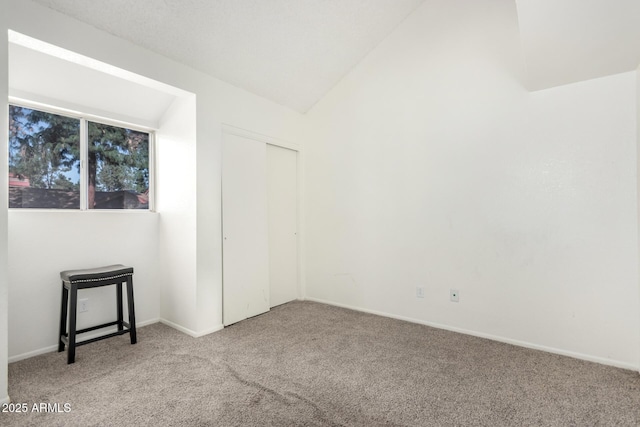 unfurnished room with carpet floors and lofted ceiling