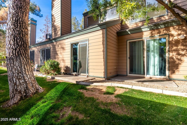 rear view of house with a lawn and a patio