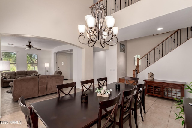 20409 W Thayer St, Buckeye, AZ 85396 - dining room with arched walkways, a high ceiling, a ceiling fan, a chandelier, and light tile patterned flooring