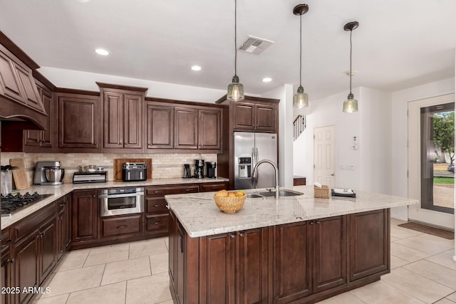 20409 W Thayer St, Buckeye, AZ 85396 - kitchen featuring appliances with stainless steel finishes, premium range hood, tasteful backsplash, light tile patterned floors, and hanging light fixtures