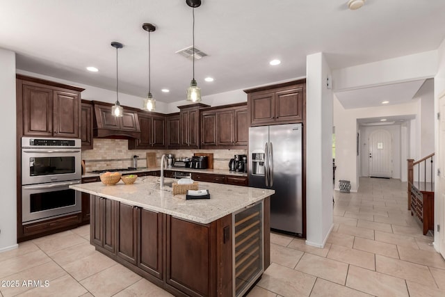 20409 W Thayer St, Buckeye, AZ 85396 - kitchen featuring appliances with stainless steel finishes, beverage cooler, backsplash, dark brown cabinets, and recessed lighting