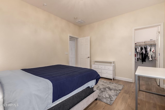 20409 W Thayer St, Buckeye, AZ 85396 - bedroom featuring wood finished floors, a walk in closet, and a closet