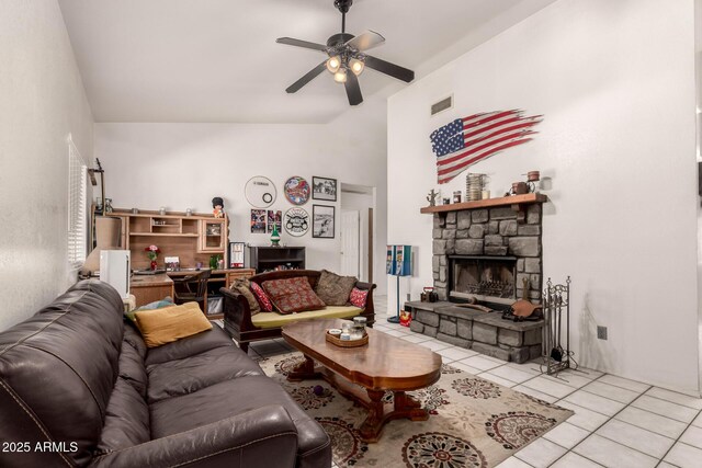 living area with light tile patterned floors, ceiling fan, a fireplace, and lofted ceiling