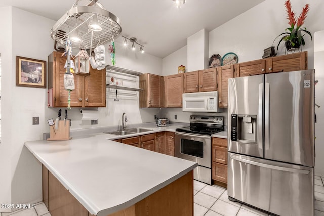 kitchen featuring stainless steel appliances, a sink, light countertops, a peninsula, and light tile patterned floors