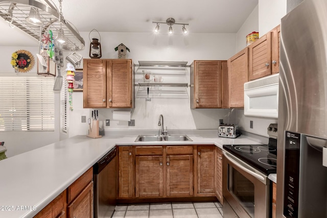 kitchen with appliances with stainless steel finishes, a sink, light countertops, light tile patterned flooring, and brown cabinetry