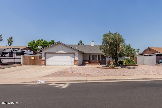 ranch-style home featuring driveway, a garage, fence, stucco siding, and a chimney