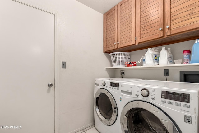 laundry room featuring washing machine and clothes dryer, cabinet space, and light tile patterned flooring