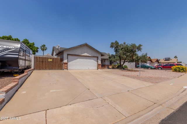 ranch-style home featuring concrete driveway, a garage, a gate, stucco siding, and brick siding