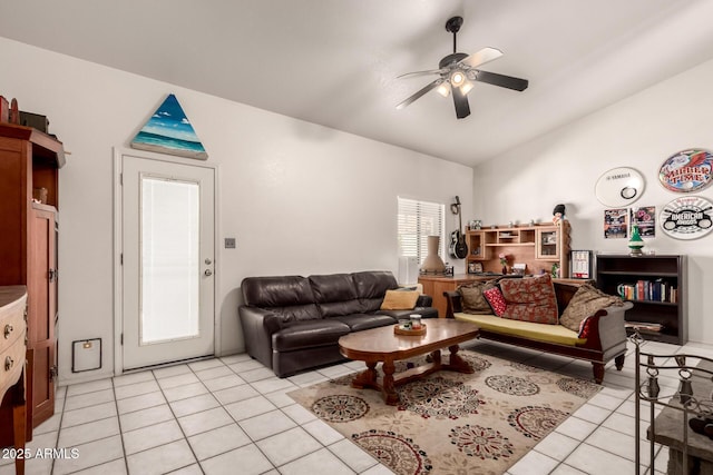 living area with light tile patterned floors, a ceiling fan, and lofted ceiling
