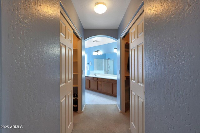 6993 S Sharon Ct, Chandler, AZ 85249 - hall with visible vents, arched walkways, a textured wall, and light carpet