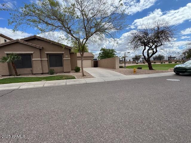 view of front of house with a tile roof, stucco siding, driveway, and an attached garage