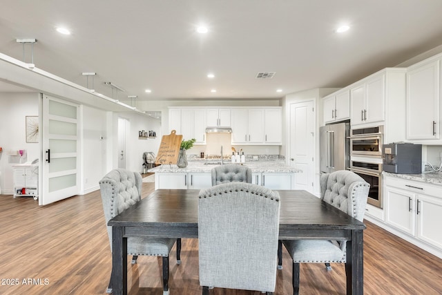 dining room with wood finished floors, visible vents, and recessed lighting