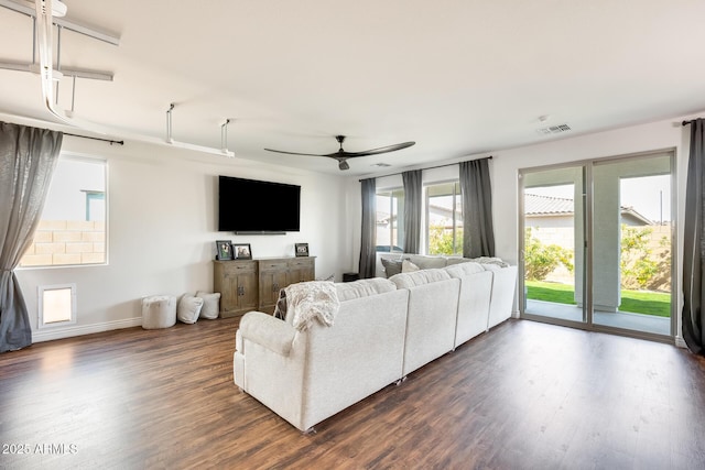 living area with a ceiling fan, dark wood-style flooring, and visible vents