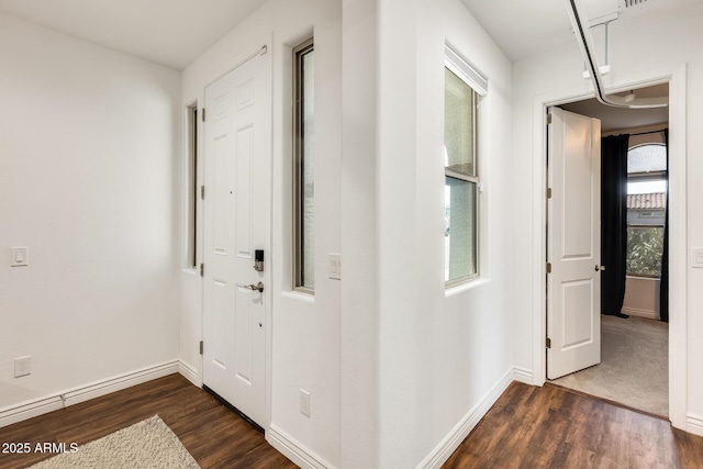 hallway featuring dark wood-style floors and baseboards