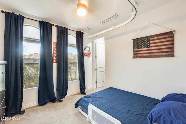 bedroom featuring light carpet and baseboards