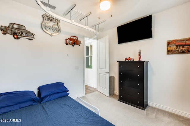 bedroom with light carpet, visible vents, and baseboards