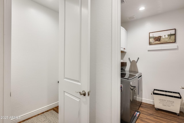 laundry area with washer and clothes dryer, dark wood finished floors, cabinet space, and baseboards