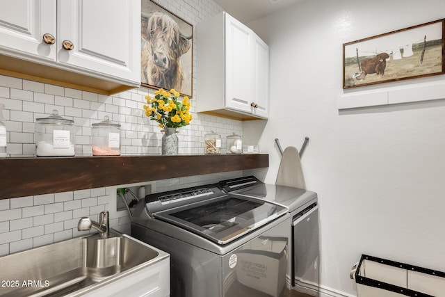 laundry area featuring cabinet space, a sink, and washing machine and clothes dryer