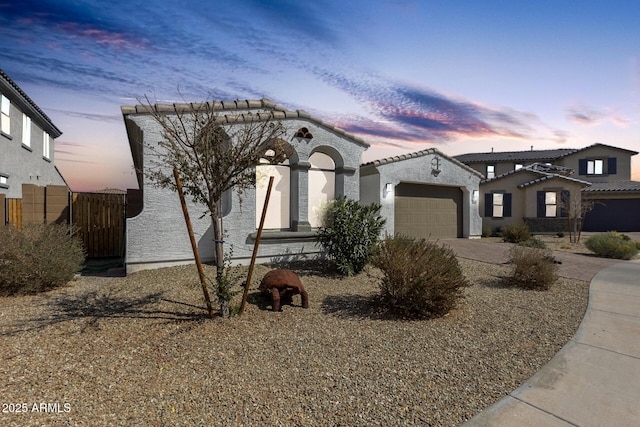 mediterranean / spanish-style house with driveway, a garage, and stucco siding