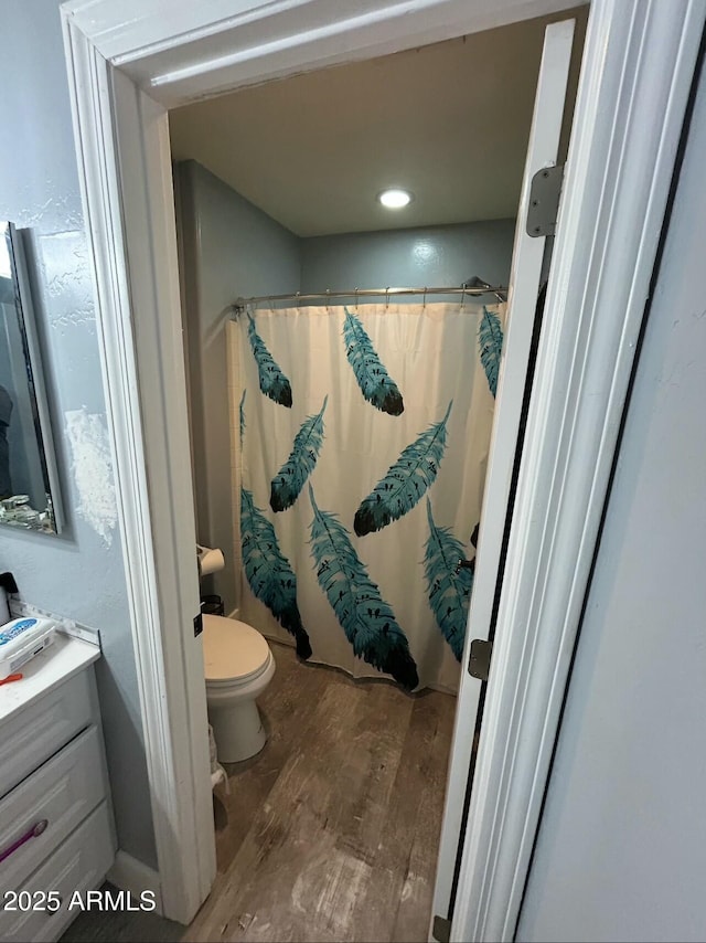 full bath with vanity, a shower with curtain, toilet, and wood finished floors