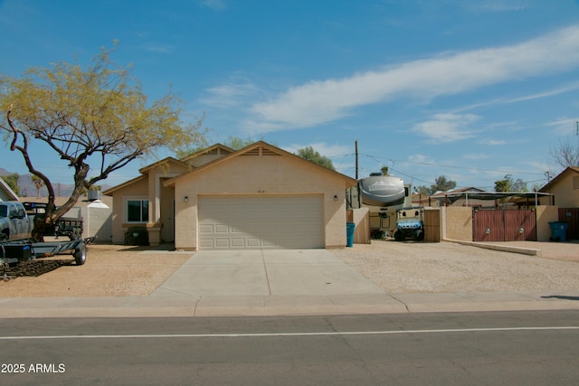 ranch-style home with an attached garage, fence, driveway, and stucco siding