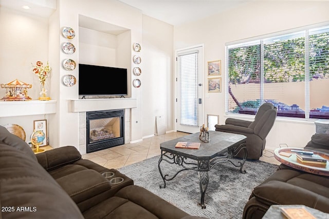 living room featuring a tiled fireplace and light tile patterned flooring