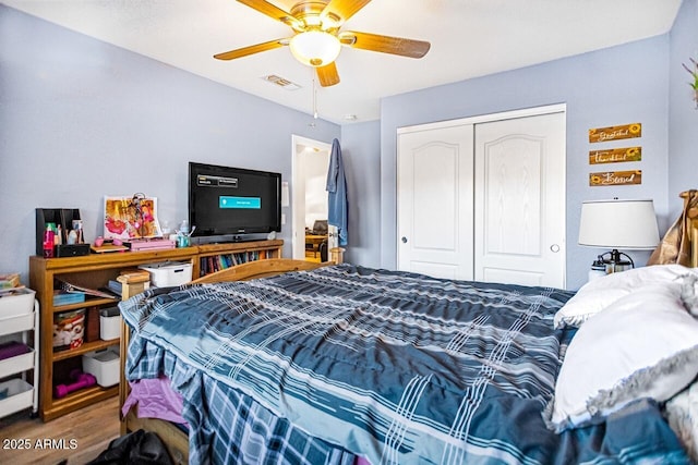 bedroom featuring ceiling fan, hardwood / wood-style floors, and a closet