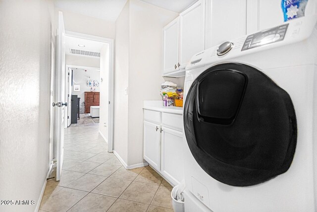 washroom with cabinets, washer / dryer, and light tile patterned floors