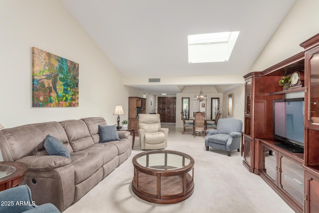 living room with light colored carpet, lofted ceiling with skylight, and a chandelier