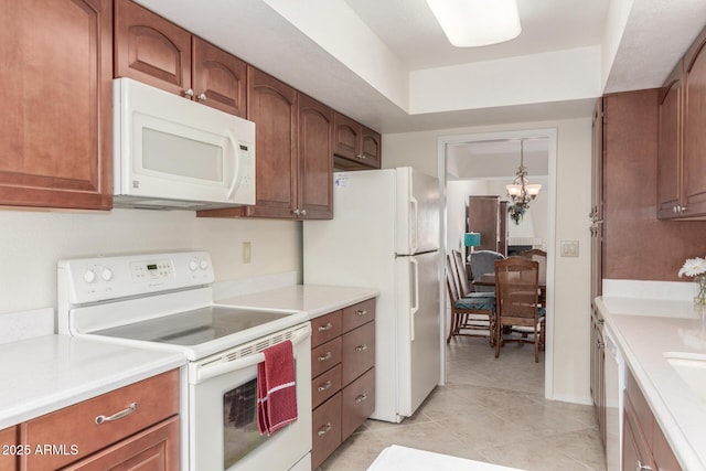 kitchen with white appliances, pendant lighting, a notable chandelier, and light tile patterned floors