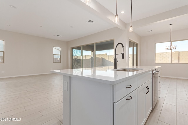 kitchen with sink, plenty of natural light, and a center island with sink