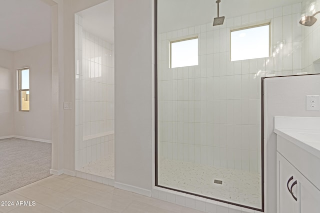 bathroom with vanity, a wealth of natural light, and tiled shower