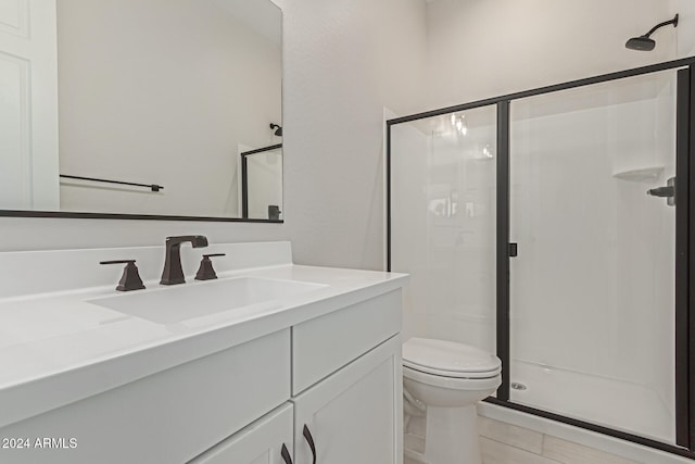 bathroom with vanity, walk in shower, toilet, and tile patterned flooring