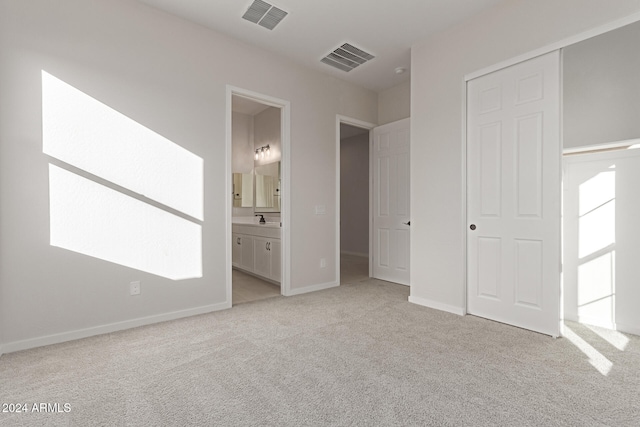 unfurnished bedroom with connected bathroom, a closet, and light colored carpet