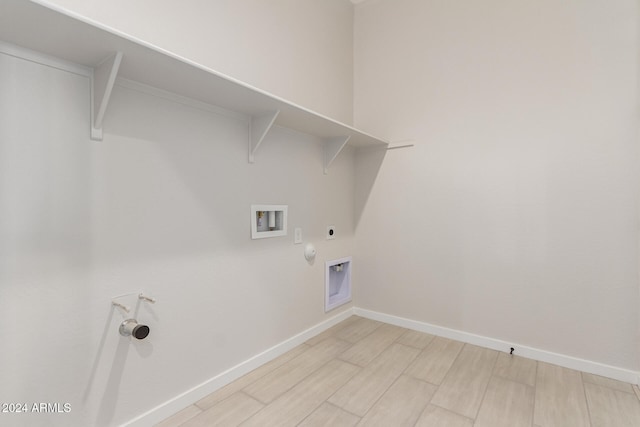 laundry room with gas dryer hookup, hookup for a washing machine, light hardwood / wood-style floors, and hookup for an electric dryer