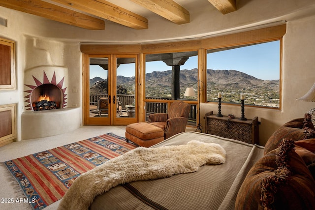 interior space featuring beamed ceiling, carpet flooring, and a mountain view