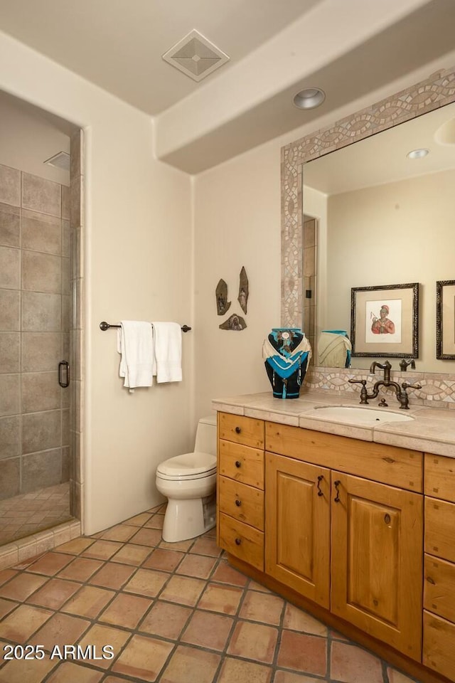 bathroom featuring vanity, toilet, tile patterned floors, and a shower with shower door