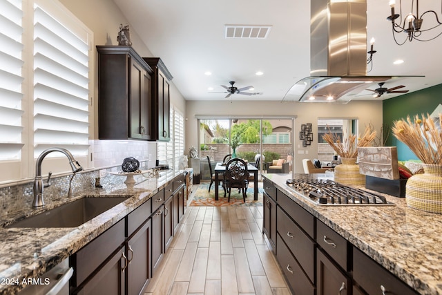 kitchen featuring sink, appliances with stainless steel finishes, tasteful backsplash, pendant lighting, and light wood-type flooring