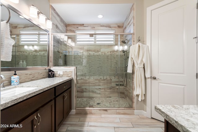 bathroom featuring an enclosed shower and vanity