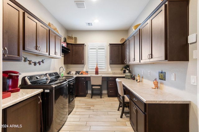 washroom featuring light hardwood / wood-style floors, cabinets, sink, and washer and dryer