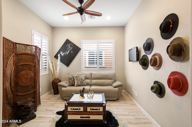 living area with light hardwood / wood-style floors and ceiling fan