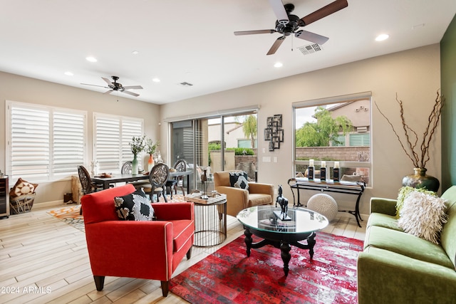 living room with ceiling fan and light hardwood / wood-style flooring