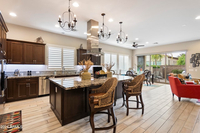 kitchen with island exhaust hood, stainless steel dishwasher, a center island, and plenty of natural light