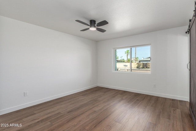 8602 N 42nd Dr, Phoenix, AZ 85051 - empty room featuring wood finished floors, ceiling fan, and a barn door